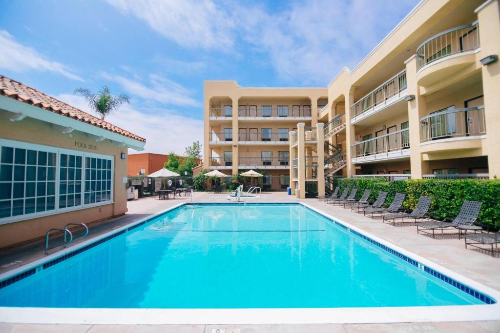 a swimming pool in front of a hotel with chairs and a building at Fairfield Inn Anaheim Hills Orange County in Anaheim