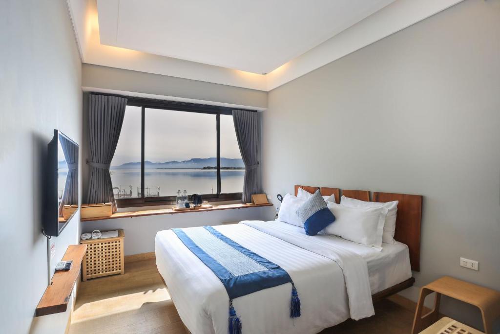 a bedroom with a large bed with a large window at Damar Toba in Balige