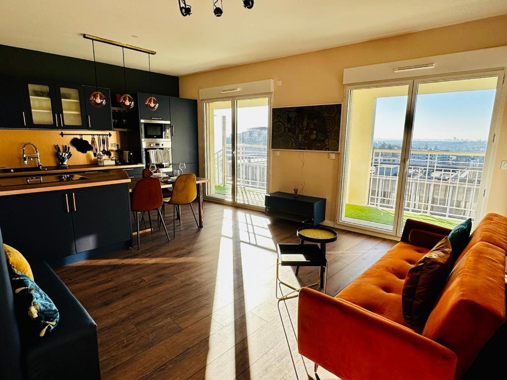 a living room with a couch and a kitchen at CHIC & CHILL Apartment near Disneyland and Paris in Noisy-le-Grand