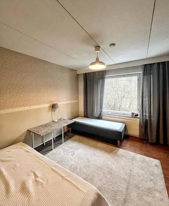sala de estar con cama y ventana en Kotimaailma - Tilava rivitalo asunto 3MH ja sauna lähellä Korson keskustaa, en Helsinki