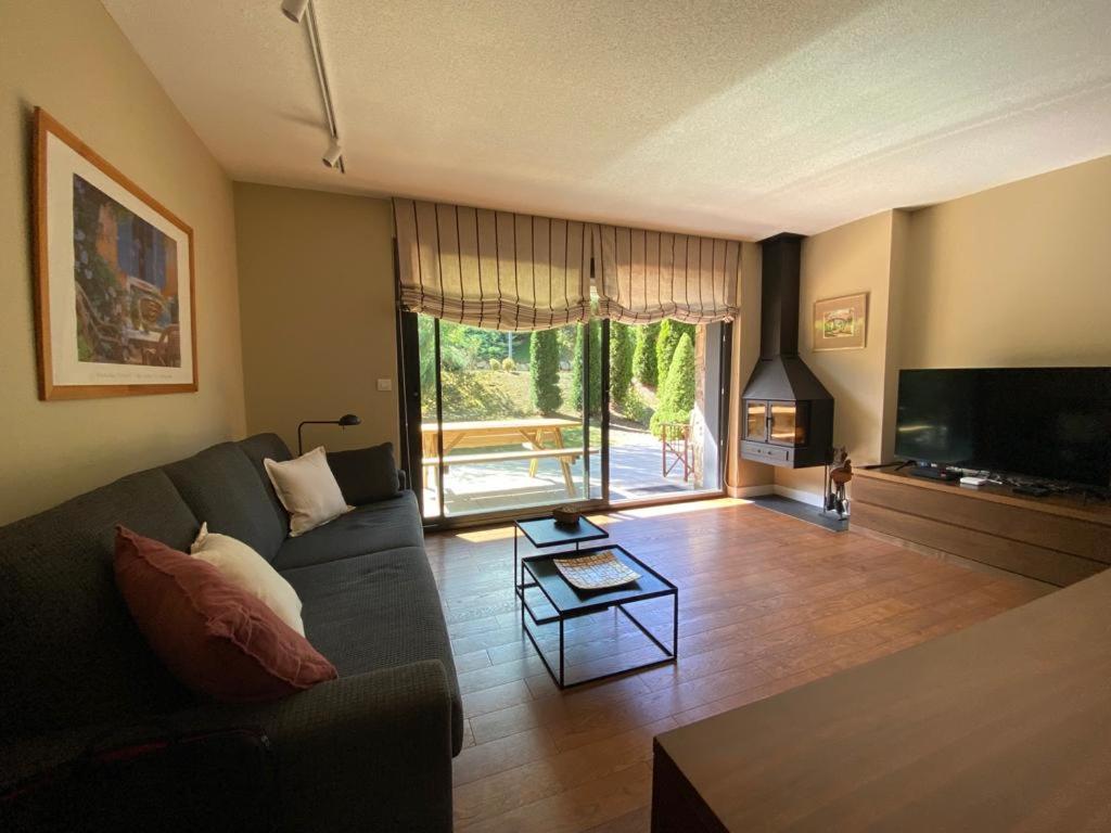 a living room with a couch and a tv at Les Ferreries Saillagouse in Saillagouse