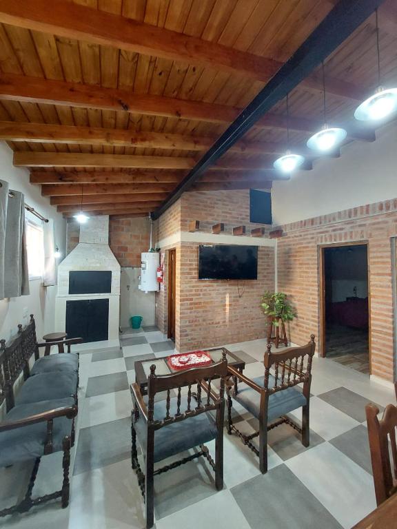 a living room with wooden ceilings and a table and chairs at Emilia II in Esquel