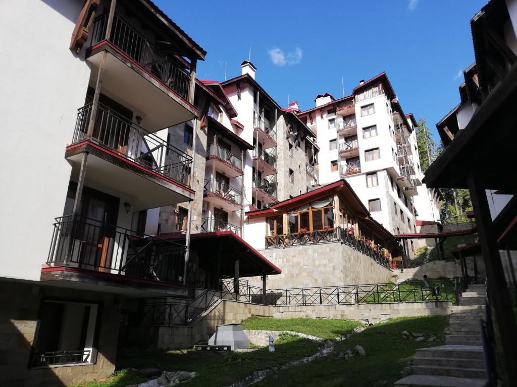 - un grand bâtiment avec des balcons et des escaliers en face dans l'établissement The Castle Mansarde on the slope 7 - Pamporovo, à Pamporovo