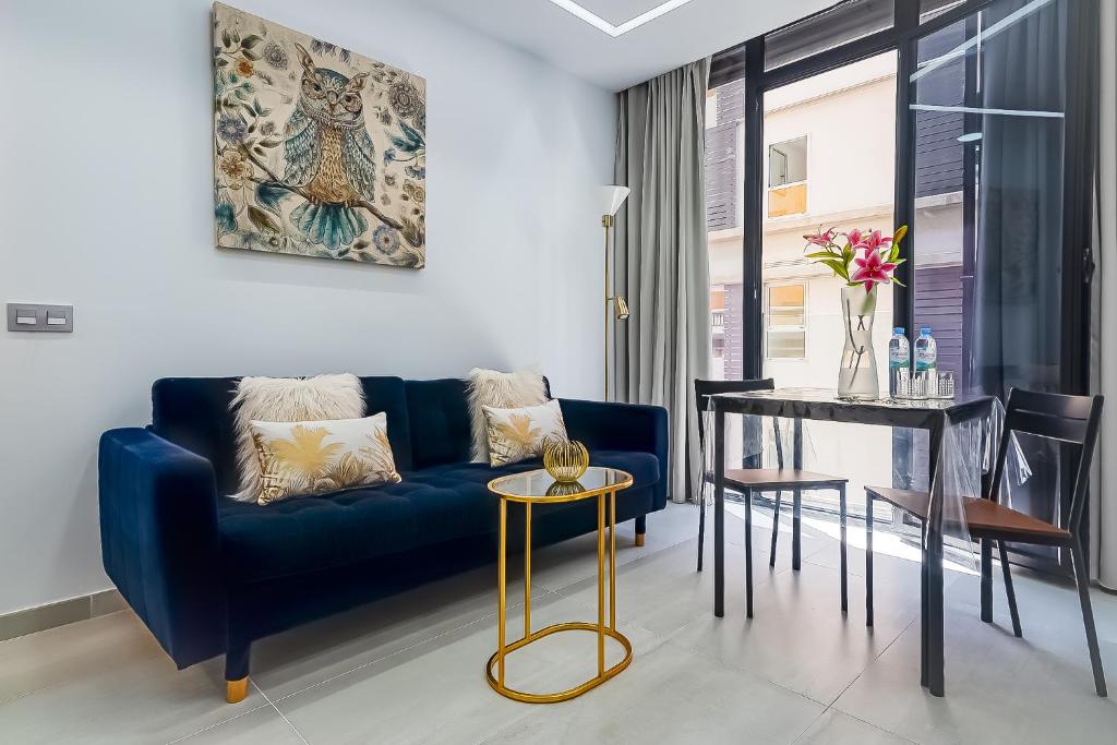 Una sala de estar con un sofá azul y una mesa. en Sun&Sea in Playa las Canteras, en Las Palmas de Gran Canaria