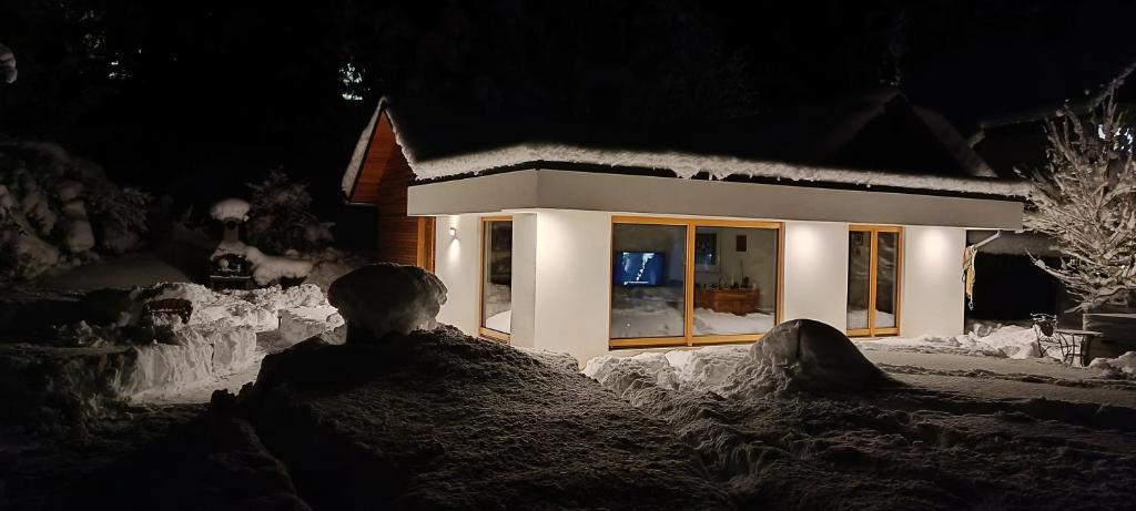 a house covered in snow at night at House Apartma Čebela with jacuzzi in Gozd Martuljek