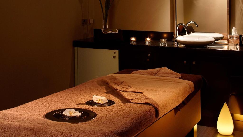 a bathroom with a bed with towels and a sink at Park Plaza London Westminster Bridge in London