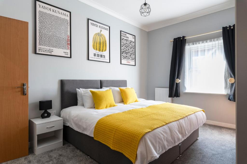 een slaapkamer met een bed met een gele deken bij Stunning 2BR, 2BA, Apartment - Super King Size Beds - Free Parking - 6 mins to LGW Airport in Crawley