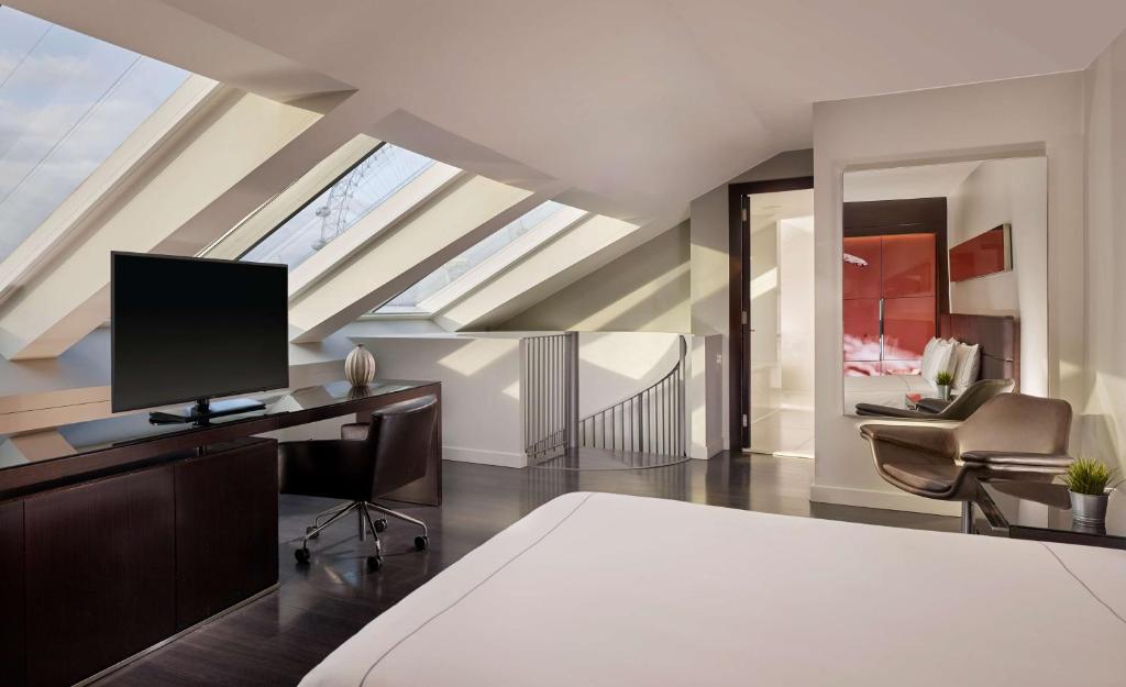 a bedroom with a bed and a desk with a television at Park Plaza London Westminster Bridge in London