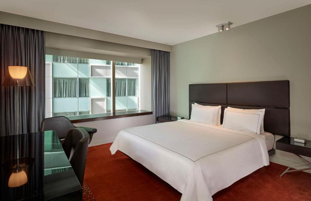 a bedroom with a large white bed and a window at Park Plaza London Westminster Bridge in London