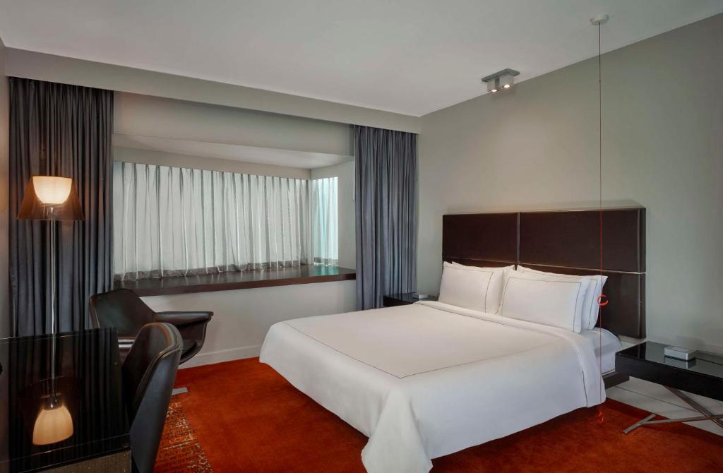 a hotel room with a white bed and a chair at Park Plaza London Westminster Bridge in London