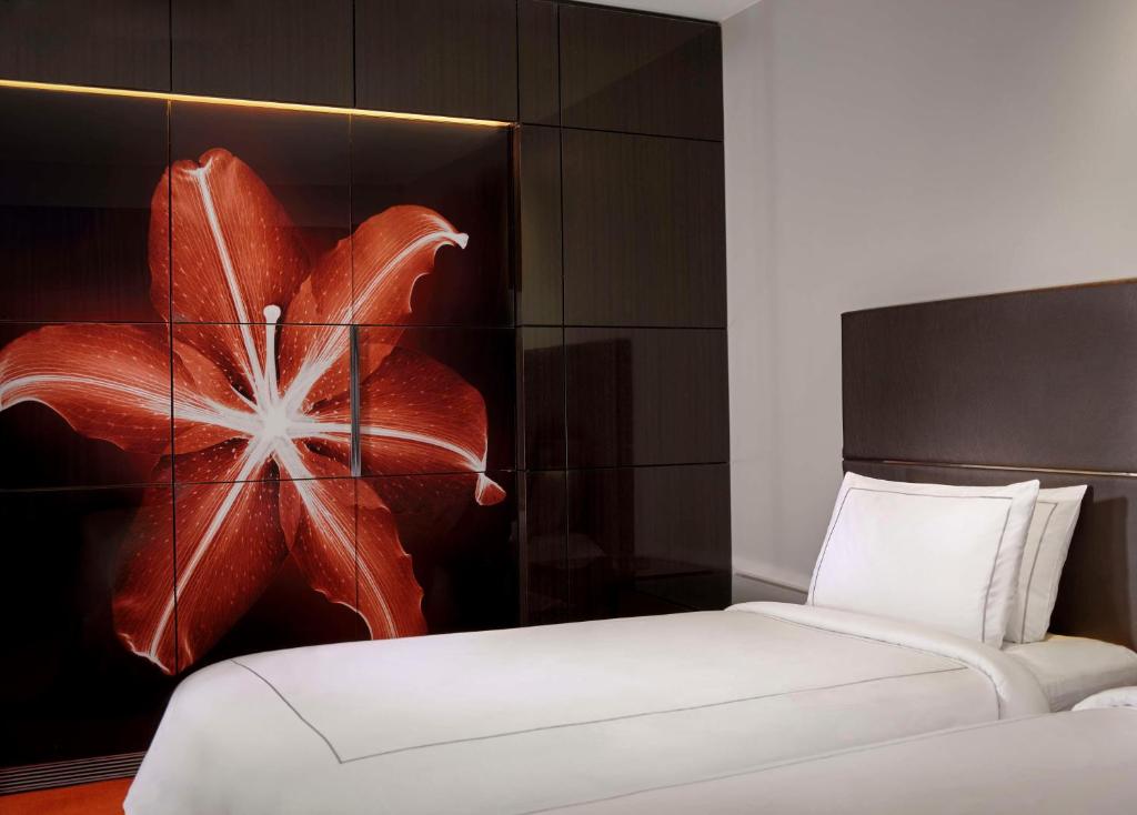 a bedroom with two beds and a painting of a flower at Park Plaza London Westminster Bridge in London