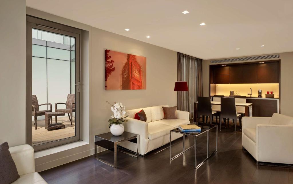 a living room with a couch and a dining room at Park Plaza London Westminster Bridge in London