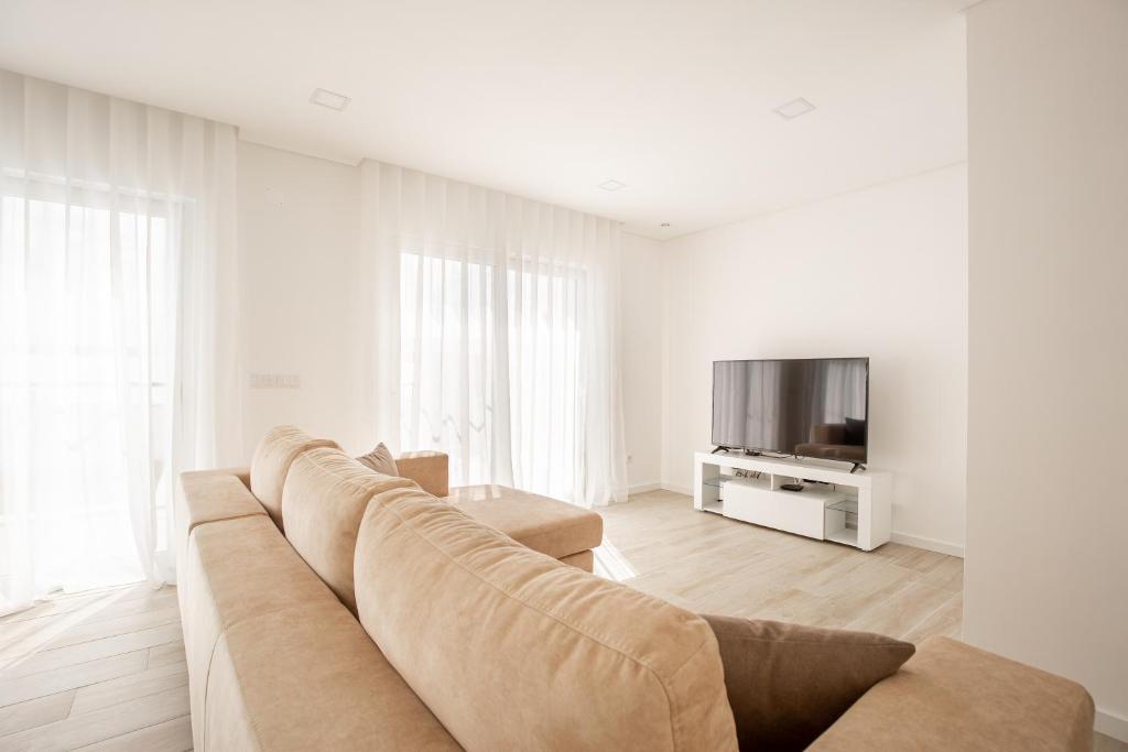 a living room with a large couch and a tv at Villa Patricia in Santa Barbara