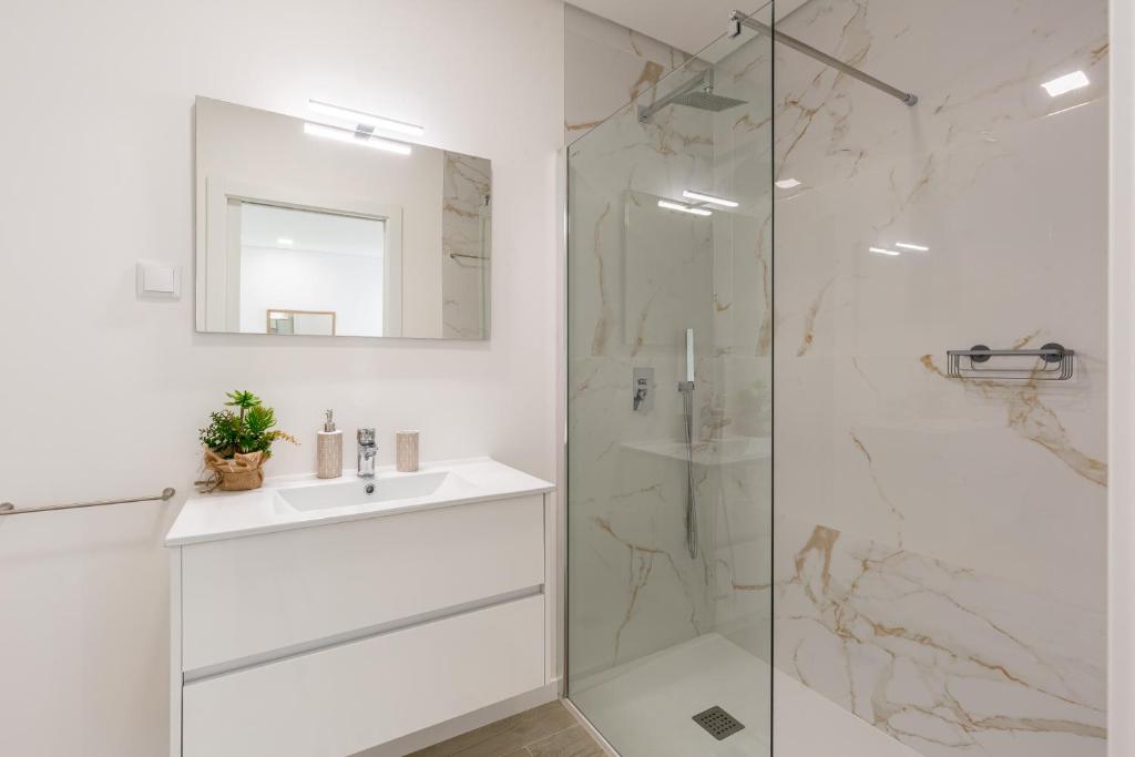 a white bathroom with a sink and a shower at Villa Patricia in Santa Barbara