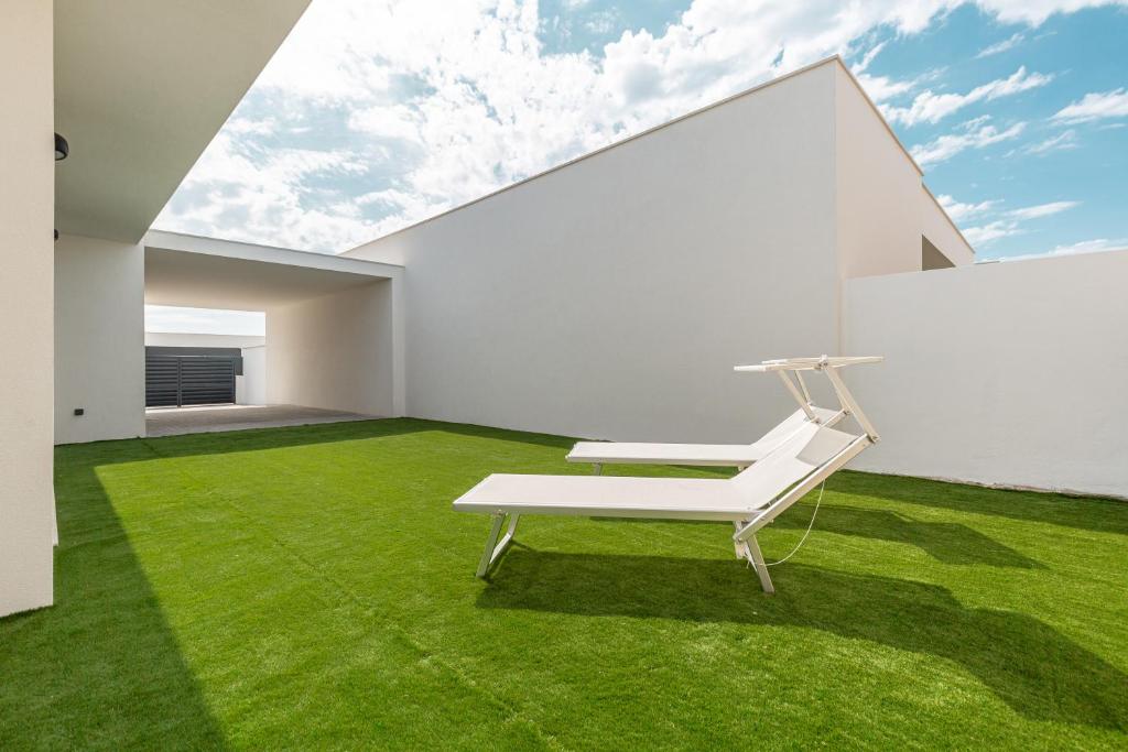 a white room with green grass and a white chair at Villa Patricia in Santa Barbara