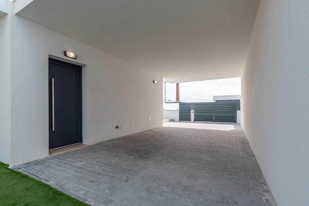 an empty hallway with a black door on a white wall at Villa Patricia in Santa Barbara