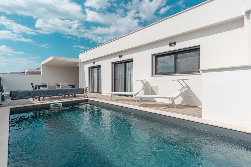 a house with a swimming pool in front of it at Villa Patricia in Santa Barbara