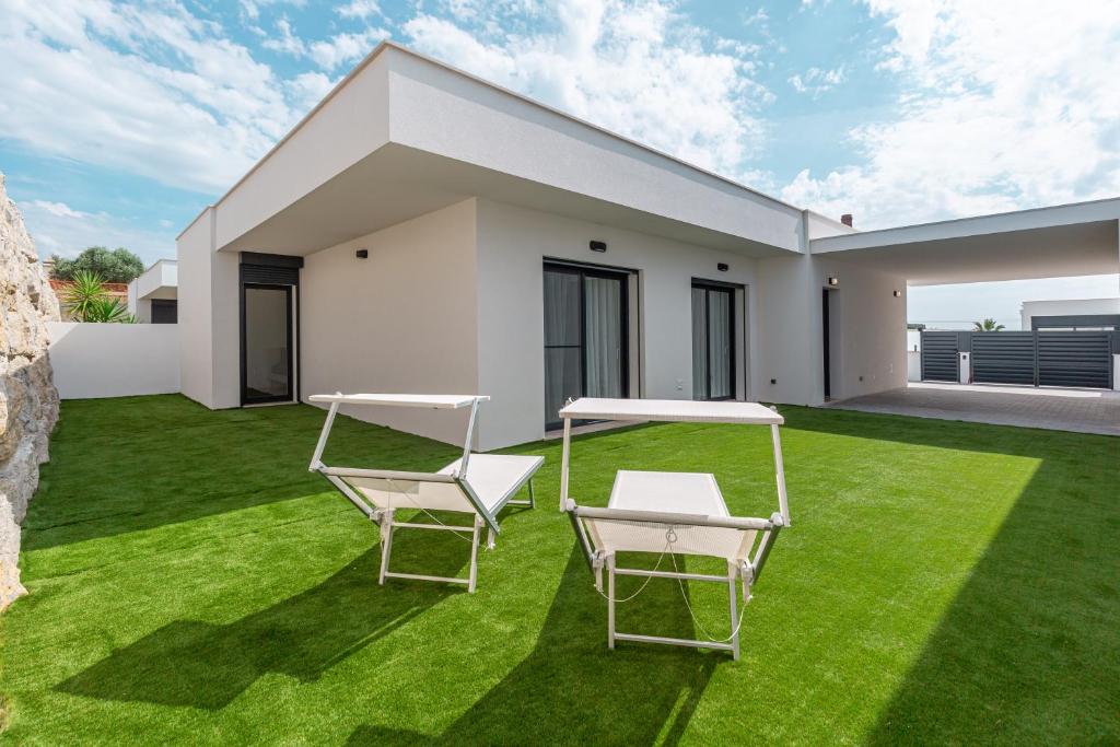 a lawn with two chairs and a table on it at Villa Patricia in Santa Barbara