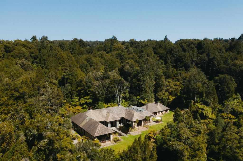 an aerial view of a group of cottages in the woods at Treetops Lodge & Estate in Horohoro