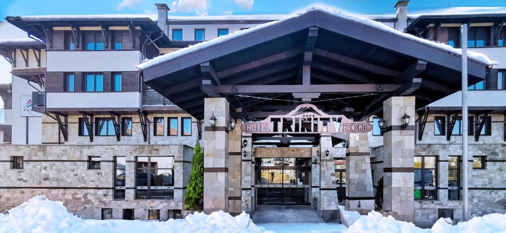 a building with snow in front of it at Trinity Residence Bansko in Bansko