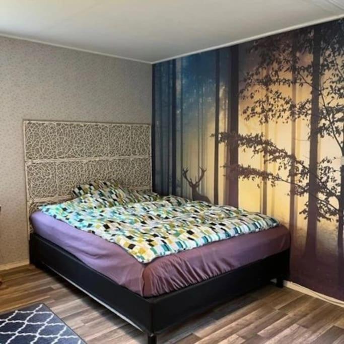 HamraにあるFamilienfreundliche Farm Stugaの壁に絵画が描かれたベッドルームのベッド1台