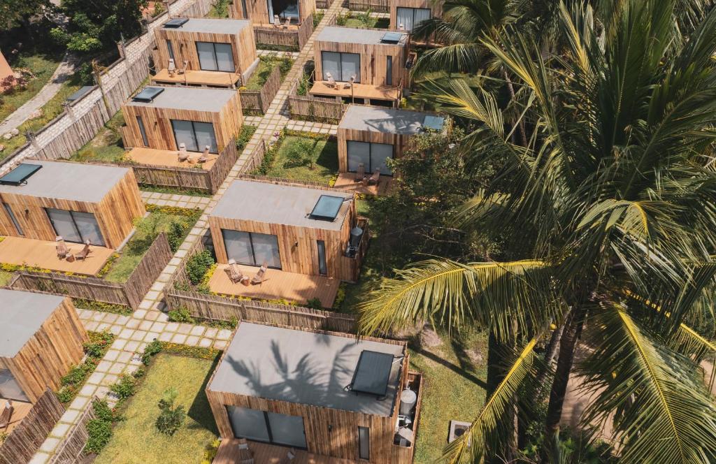 an overhead view of a bunch of houses with a palm tree at LalaGalu - Beachfront EcoCabins in Diani Beach