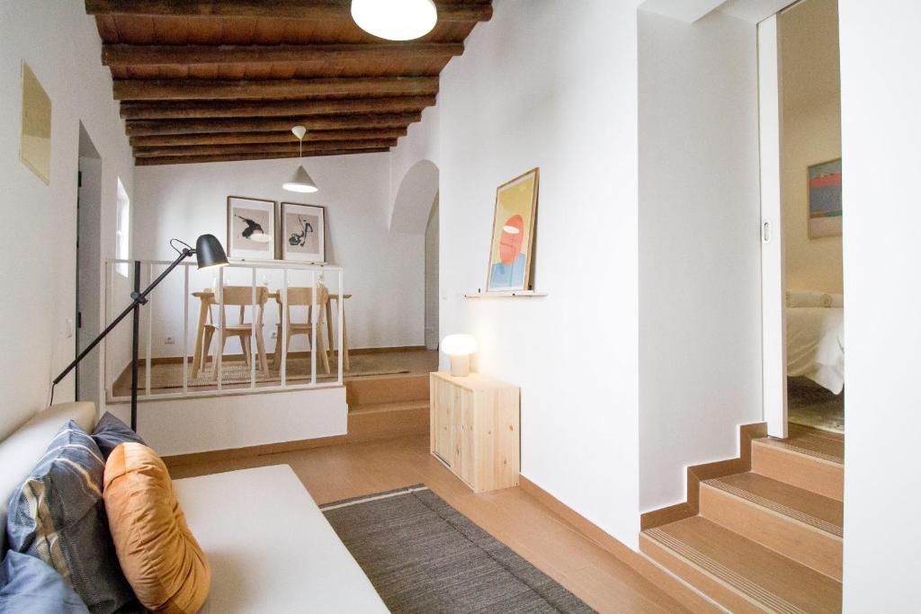 a living room with white walls and wooden ceilings at Comfortable getaway in Medieval Castro Marim in Castro Marim