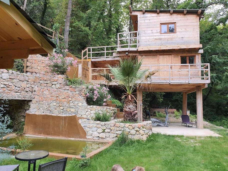 una gran casa de madera con un estanque en el patio en cabane, en Aspremont