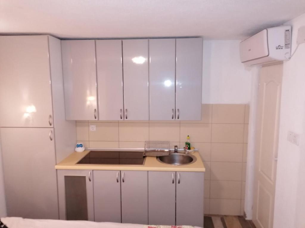 eine Küche mit weißen Schränken und einem Waschbecken in der Unterkunft Apartmani Milica in Banja Luka