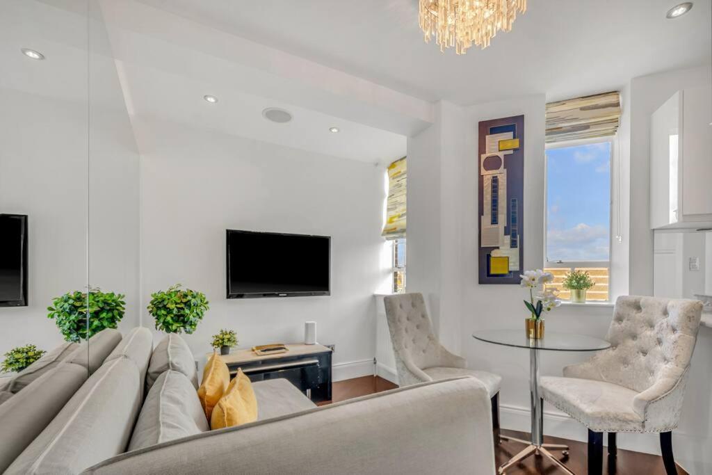 uma sala de estar com um sofá e uma mesa em Modern One Bed Serviced Apartment in Chelsea em Londres