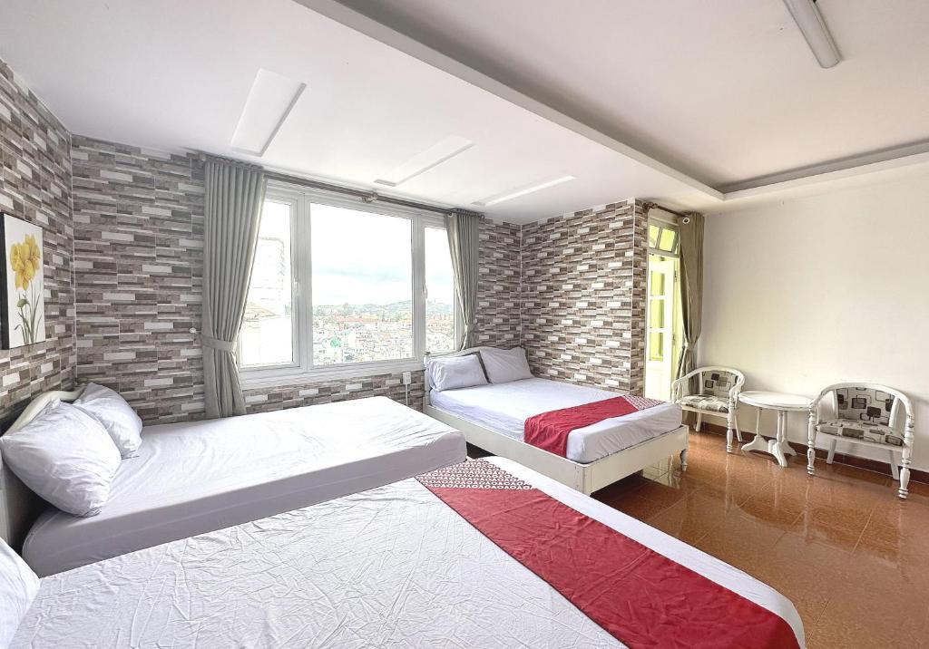 sypialnia z 2 łóżkami i ceglaną ścianą w obiekcie OYO 1196 Le Vu Hotel w mieście Da Lat