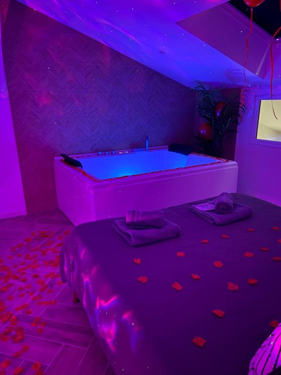 una mesa de billar en una habitación con iluminación púrpura en L'apothéose, appart avec balnéo, en Le Luc
