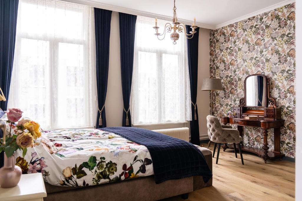 a bedroom with a bed and a desk and windows at De Jonge Barones in Beetsterzwaag