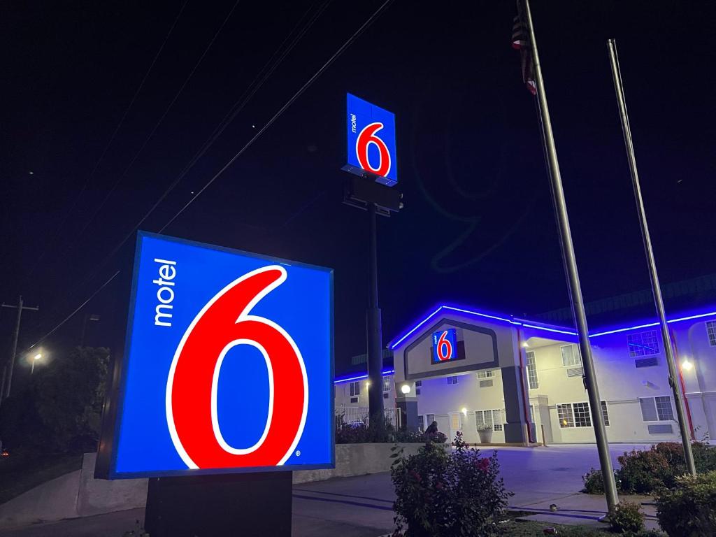 una señal para una gasolinera por la noche en Motel 6 Tulsa, OK Airport, en Tulsa