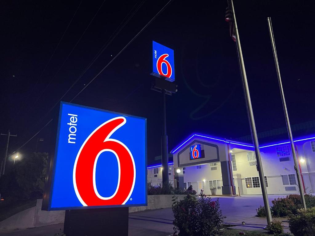 a sign for a gas station at night at Motel 6 Tulsa, OK Airport in Tulsa