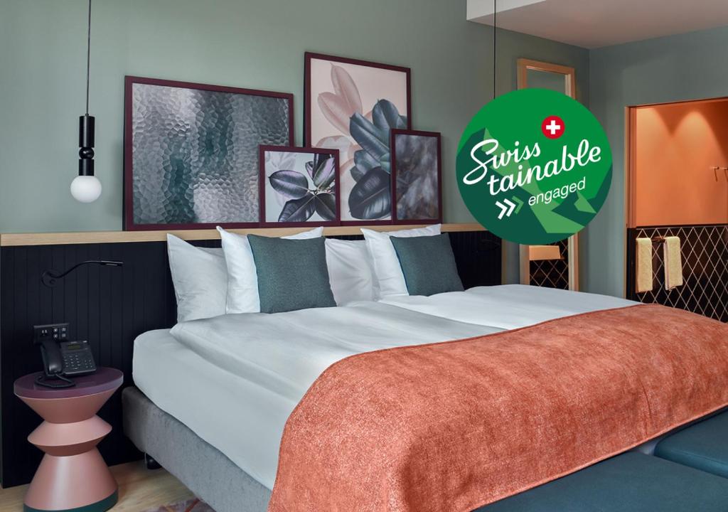 a bedroom with a large bed with a green sign at Sorell Hotel St. Peter in Zurich
