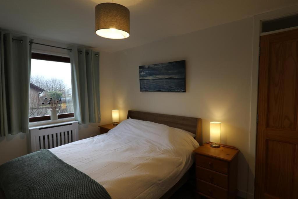 a bedroom with a bed and a window and two lamps at 16 Station Square in Saint Marys