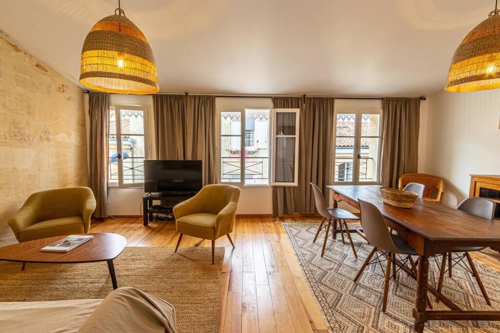 un salon avec une table et des chaises dans l'établissement Bordeaux Jardin Public : T3 Rénové Immeuble Pierre, à Bordeaux