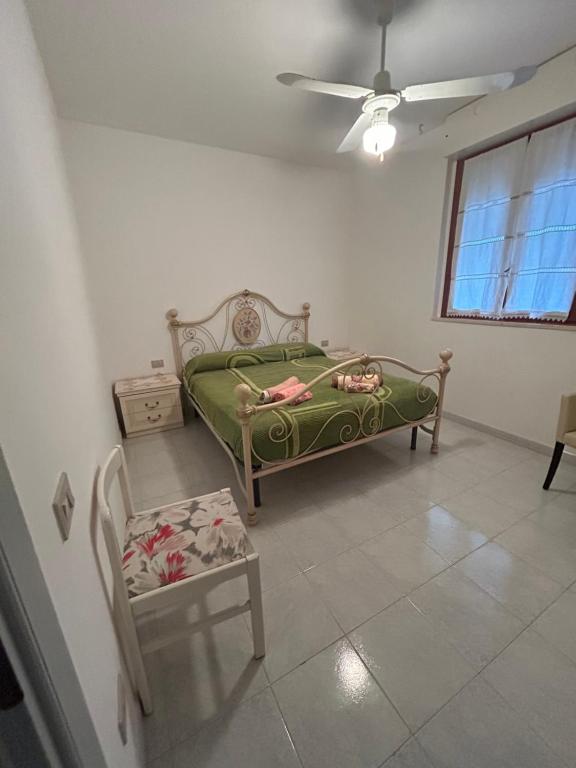 a bedroom with a green bed and a chair at PM 15 Via Liguria Guest House in Alghero