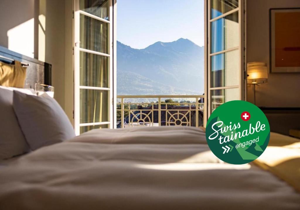 a bedroom with a bed with a view of a mountain at Sorell Hotel Tamina - Garni in Bad Ragaz