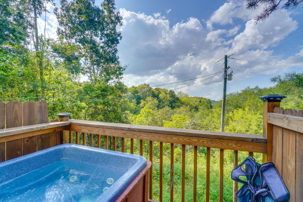 a hot tub on a wooden deck with trees at Sevierville Studio Cabin Rental with Private Hot Tub in Sevierville
