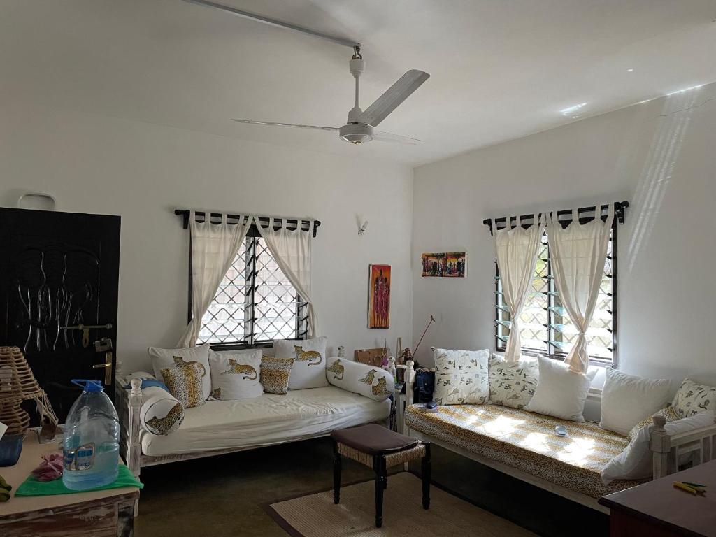 a living room with a white couch and two windows at Villa 23 in Malindi