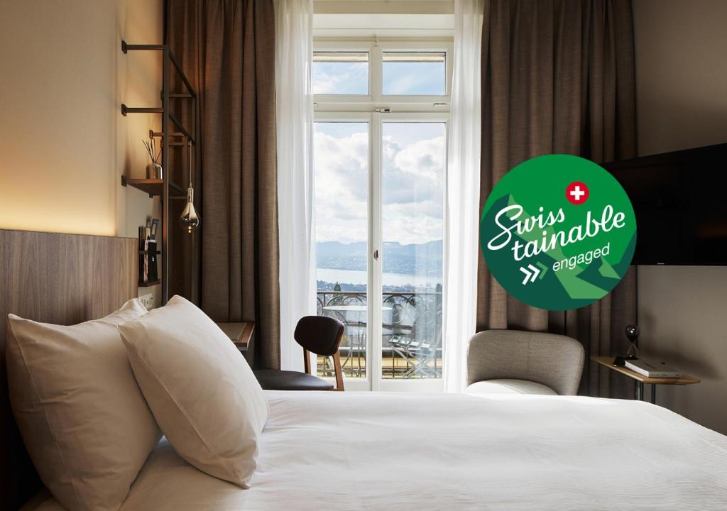 a hotel room with a bed and a window at Sorell Hotel Zürichberg in Zurich