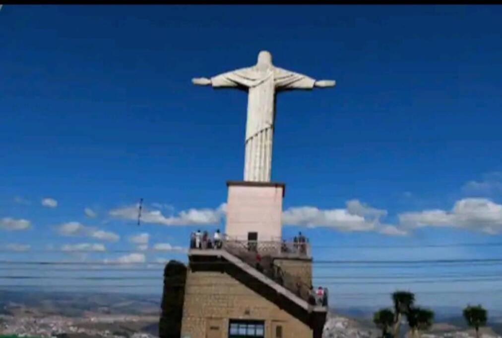 Une statue de christ le rédempteur au-dessus d'un bâtiment dans l'établissement Apartamento ao lado Praça Central, à Poços de Caldas