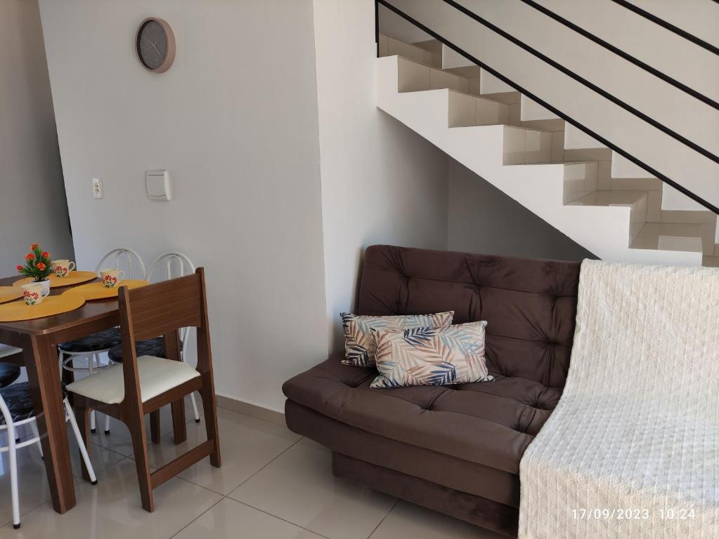 a living room with a couch and a table and stairs at Sobrado novo vista para o Cristo in Encantado