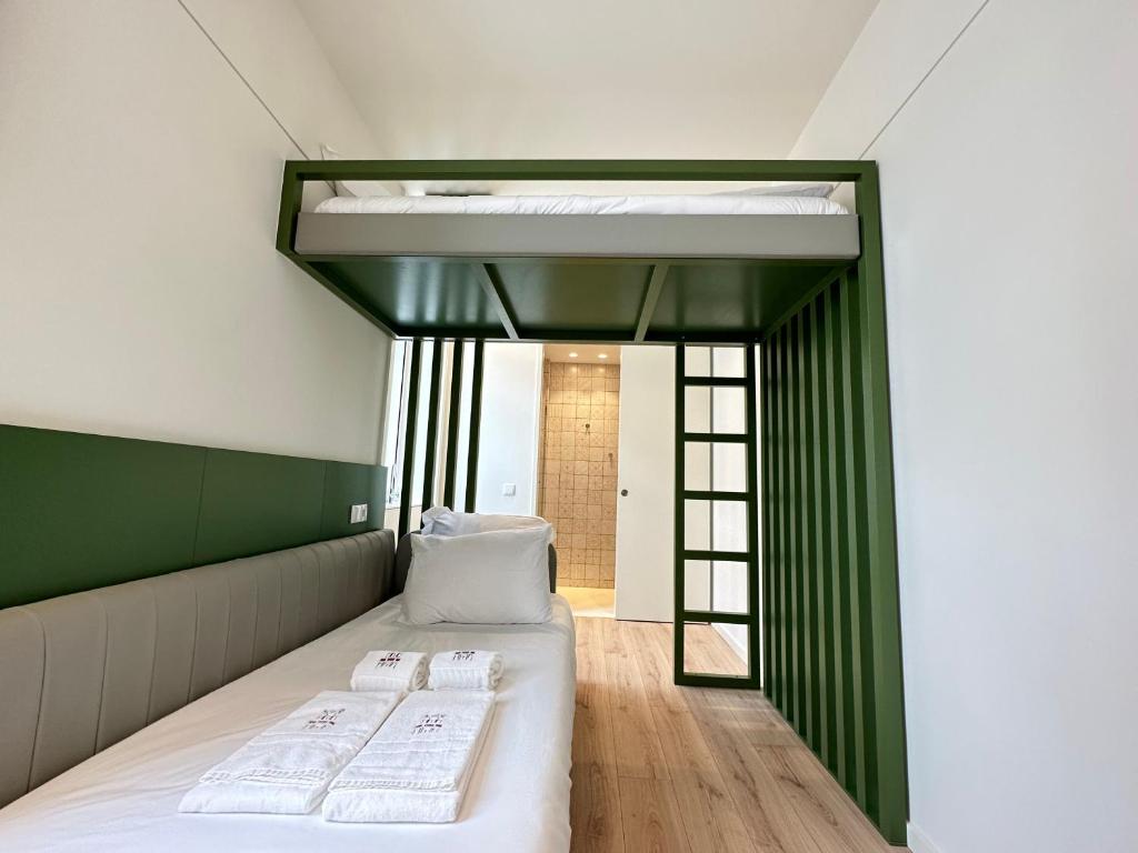 a bedroom with a bed with two white sheets at A'MAR by Alojamento Ideal in Póvoa de Varzim