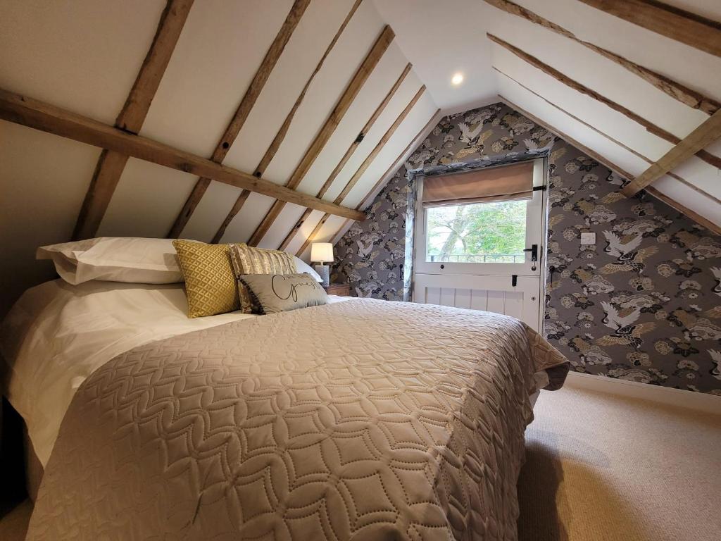a bedroom with a large bed in a attic at The Manor Pen in Lenham