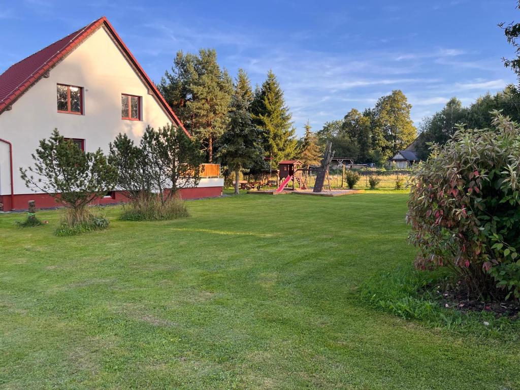 a large yard with a house and a playground at Meadows House Lomnice in Lomnice