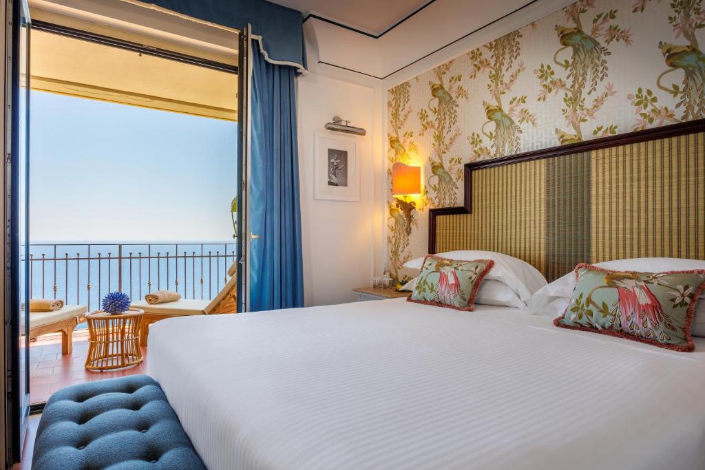 a bedroom with a large bed and a balcony at Grand Hotel San Pietro Taormina in Taormina