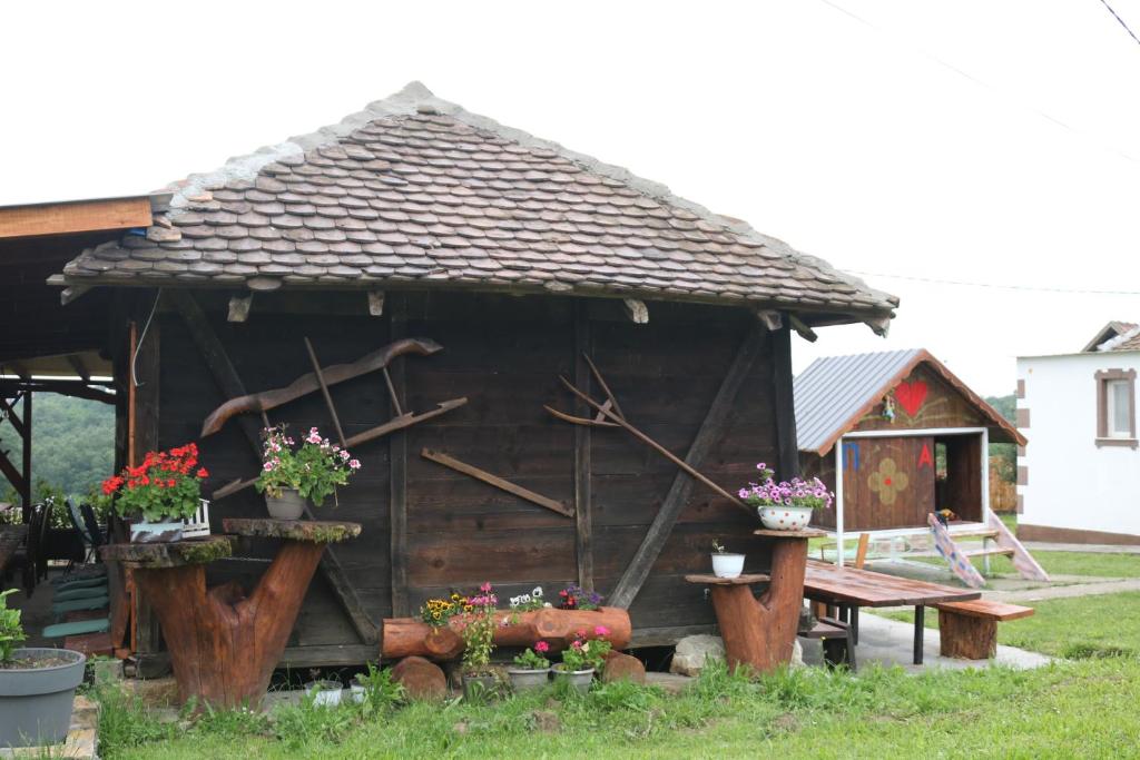 une petite maison avec une table de pique-nique et des fleurs dans l'établissement Etno san, à Šiljakovac